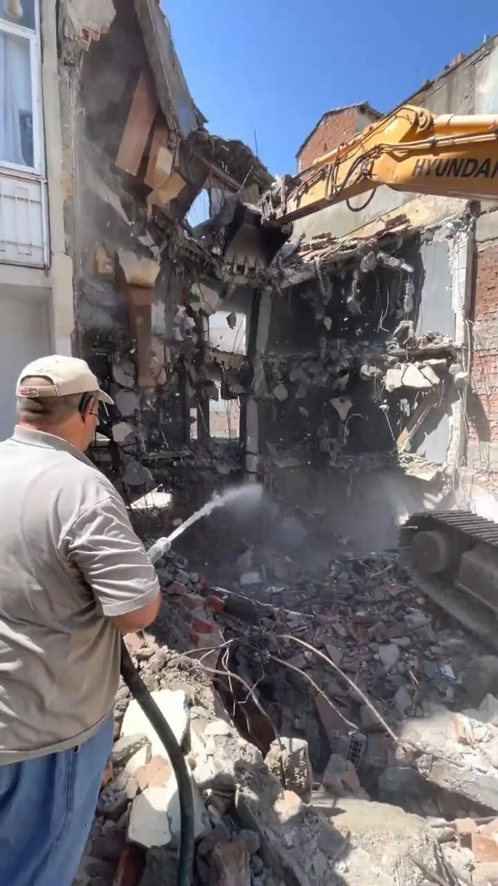 挖掘机钢铁巨臂狂拆旧建筑，工人洒水控尘